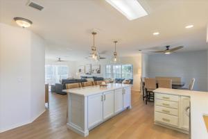 Il comprend une cuisine et un salon avec des placards blancs et un canapé. dans l'établissement Dock Holiday, à Sanibel