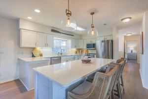 une cuisine avec un grand îlot avec des chaises dans l'établissement Dock Holiday, à Sanibel