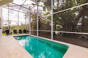 a swimming pool in front of a building with windows at Dock Holiday in Sanibel