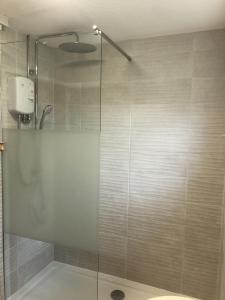 Un baño con ducha con puerta de cristal. en Tideaway, en Trearddur 29 fotos más