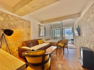 a living room with a couch and a tv at Sea view Studio Terminal in Budva