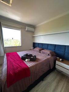 een slaapkamer met een bed met een koffer erop bij Apt Ilhéus próximo a Praia dos Milionários in Ilhéus