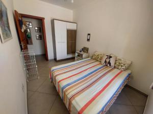 a bedroom with a bed with a colorful striped blanket at Apartamento de Torres perto do Mar in Torres