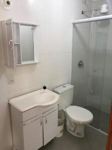 a bathroom with a toilet and a sink and a shower at Apartamento de Torres perto do Mar in Torres +10 photos
