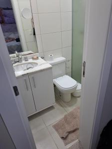 a bathroom with a toilet and a sink and a mirror at Apartamento de Torres perto do Mar in Torres