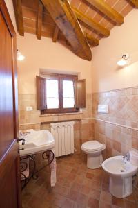 ein Badezimmer mit Waschbecken und Toilette und einem Fenster in der Unterkunft Corte Delle Stelle in Cortona