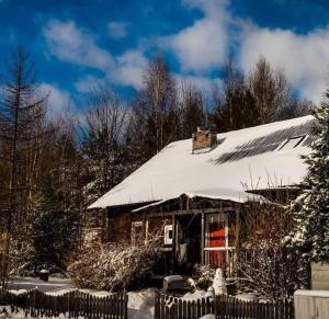 a house covered in snow with a fence at Dom z Duszą Pomlewo in Pomlewo