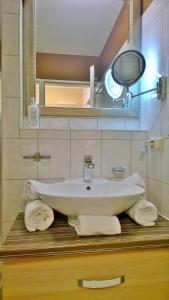 a bathroom with a sink and a mirror and towels at Ostsee Ferienappartement Dierhagen-Strand in Dierhagen +49 photos