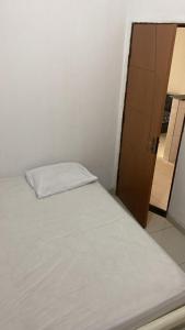 a bed with a white pillow in a room at Chalé Di vino in Porto Seguro