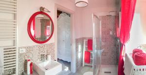 Baño rosa con lavabo y espejo en Bed & Breakfast Barbara, en Borgo Grotta Gigante
