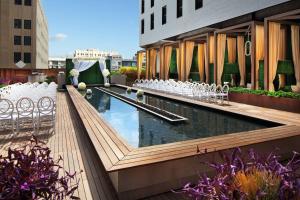a pool on the roof of a building with chairs at Sheraton Grand Los Angeles in Los Angeles