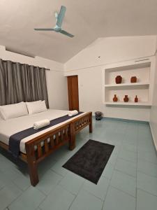 una camera con letto e ventilatore a soffitto di Yog Hostel Varkala a Varkala