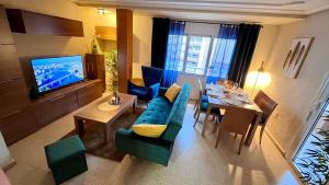 a living room with a blue couch and a television at Apartament Playa La Mata in La Mata