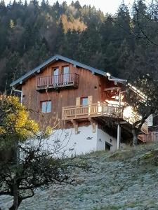 a house with a deck on the side of it at Chalet La Petite Grange in Savoie