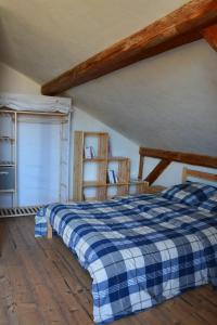 a bedroom with a blue and white checkered bed at Chalet La Petite Grange in Savoie