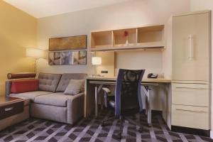 a small living room with a couch and a desk at TownePlace Suites Joliet South in Joliet