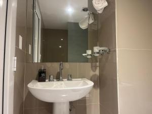 ein Badezimmer mit einem weißen Waschbecken und einem Spiegel in der Unterkunft Estudio 12 - Mural Home in Santiago del Estero