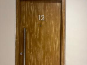 eine Holztür mit der Nummer drauf in der Unterkunft Estudio 12 - Mural Home in Santiago del Estero