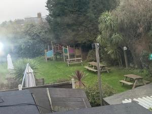 a garden with chairs and a table and a picnic table at Minster Meze & Grill BNB in Minster +1 photo