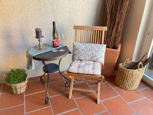 a chair and a table with a bottle of wine at Ferienhaus an der KIostermauer in Speyer