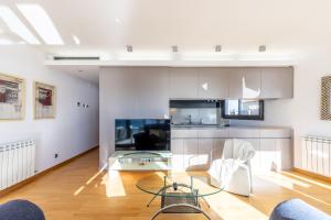 カンブリルスにあるTROPIMAR LUXE Apartment - Only Familiesのガラスのテーブルと椅子のあるリビングルーム