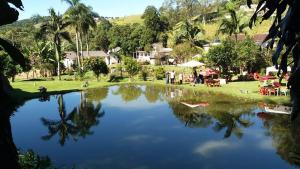a reflection of a pool of water in a yard at Chalé Sol de Primavera in Arujá