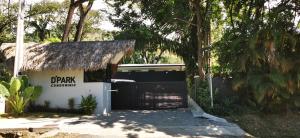 a garage with a thatch roof and a black gate at Casa Remy - Walk to the Beach and stay in a private compound! Pool, Kitchen, AC, Wi-Fi in Mal País
