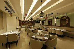a restaurant with tables and chairs in a room at Tulip Inn Zirakpur in Chandīgarh