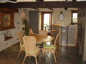 a kitchen and dining room with a table and chairs at Les Hôtes du Lac, Chambres et tables d'hôtes in Mandailles