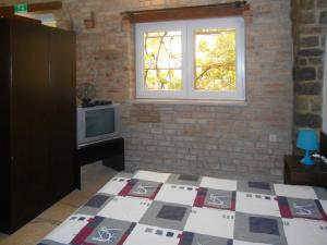 a room with a bed and a window and a television at Apartments Škrobot in Senj