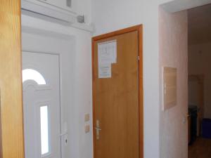 a hallway with a wooden door and a window at Apartments Škrobot in Senj