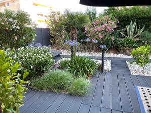a garden with plants and flowers on a wooden deck at Les Enganes in Fréjus