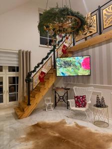 a living room with a staircase with a tv at Jaki tu spokój Domek w Bieszczadach in Wojtkowa