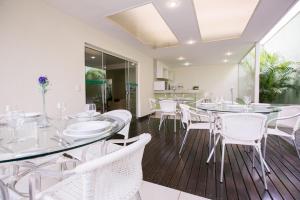 un comedor con sillas y mesas blancas en Verona Hplus Long Stay, en Brasilia