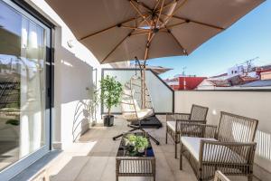 a patio with chairs and an umbrella on a balcony at ATyCO Madrid in Madrid