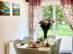 a dining room with a table and chairs and a window at Fionas thatched cottage eile in Killarney