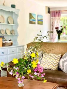 salon z kanapą i kwiatami na stole w obiekcie Fionas thatched cottage eile w Killarney