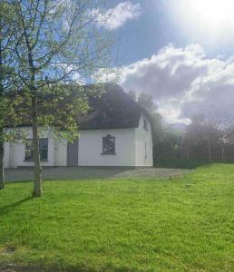 Biała stodoła z dachem krytym strzechą na polu w obiekcie Fionas thatched cottage eile w Killarney