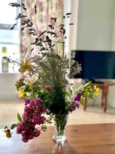 wazon wypełniony kwiatami na stole w obiekcie Fionas thatched cottage eile w Killarney +24 zdjęcia