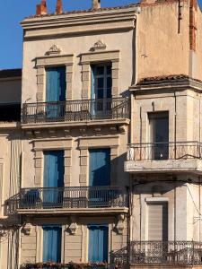 ein altes Gebäude mit seitlich gelegenen Balkonen in der Unterkunft Vue exceptionnelle sur le canal in Sète