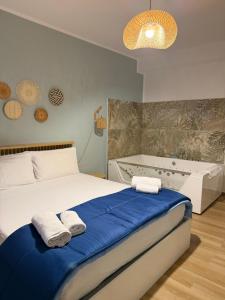 a bedroom with a bed and a tub with towels at Sea and Sand's Ville HOWME in Bari