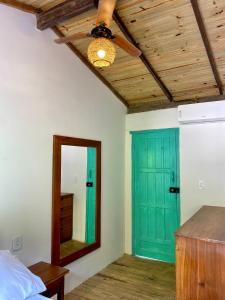 Una habitación con una puerta verde y un espejo. en Apto 1030, en Trancoso