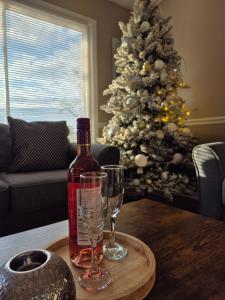 a bottle of wine and a glass on a table with a christmas tree at A Beautiful Sunset in Clarksville
