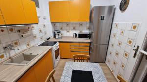 a small kitchen with yellow cabinets and a sink at Apartment Justina in Staré Mesto
