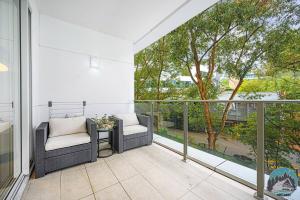 a balcony with two chairs and a table at Aircabin - Gordon - Modern - 2 Beds Apt Free Park in Gordon