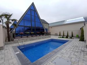 a swimming pool in front of a building with a church at A Frame Houses in Sheki