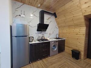 a kitchen with a refrigerator and a washing machine at A Frame Houses in Sheki