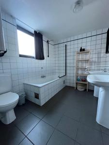 a bathroom with a tub and a toilet and a sink at Maison des M in Houffalize +30 photos