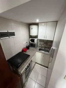 a small kitchen with a stove and a microwave at Colibri MDQ in Mar del Plata