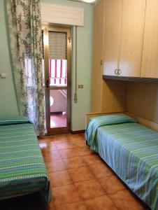 a room with two beds and a door to a room at bandiera blu in Marina di Gioiosa Ionica